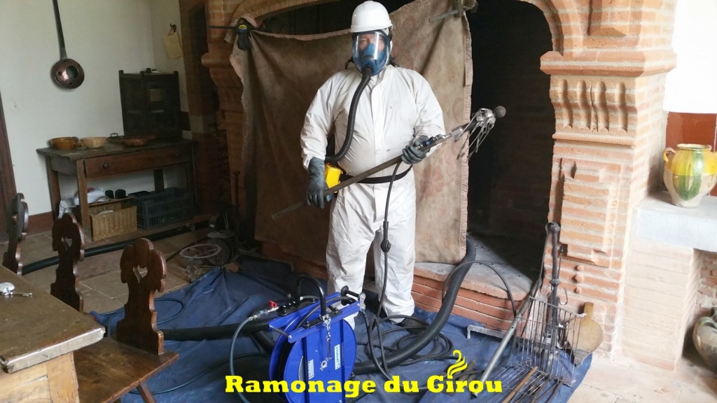 Ramonage d'une cheminée toulousaine. Combinaison et masque ventilé sont nécessaires ainsi que le port du casque.