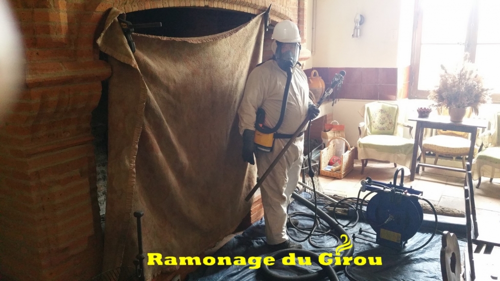 Ramonage d'une cheminée toulousaine. Combinaison et masque ventilé sont nécessaires ainsi que le port du casque.